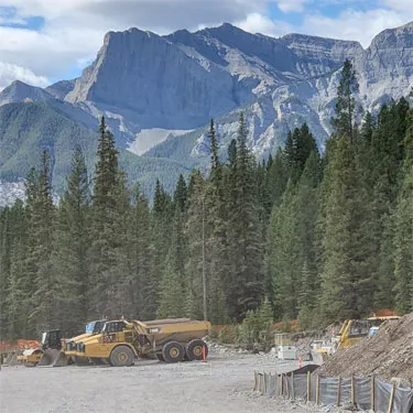 Articulated Rock Trucks by a Mountain Side